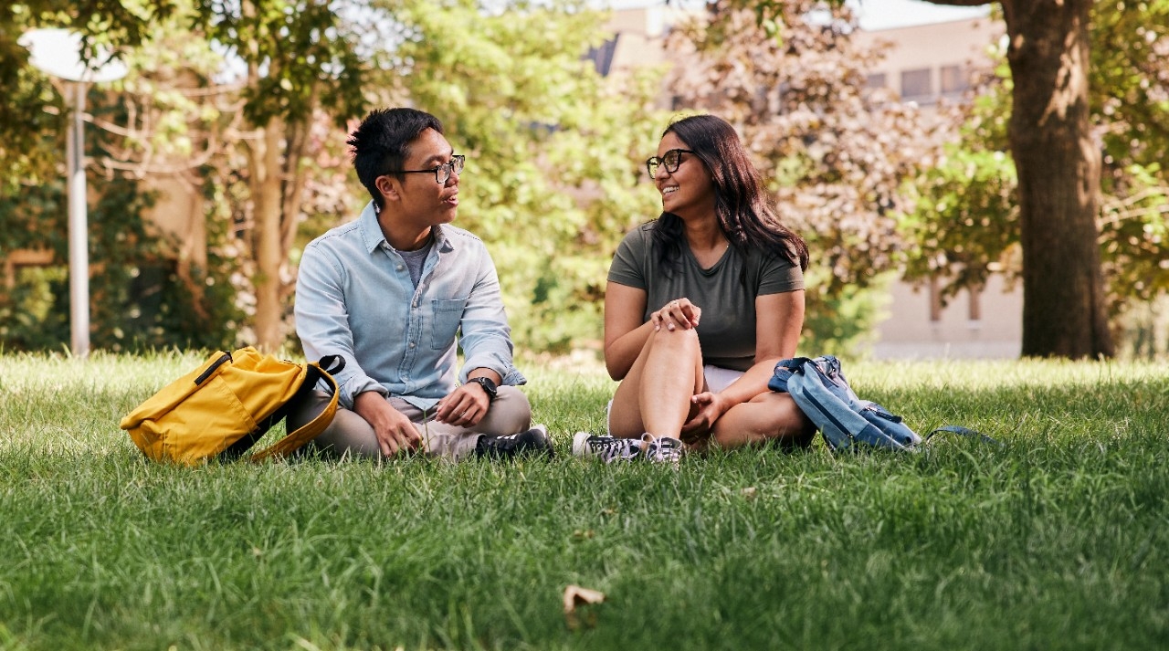 students hanging out in grass