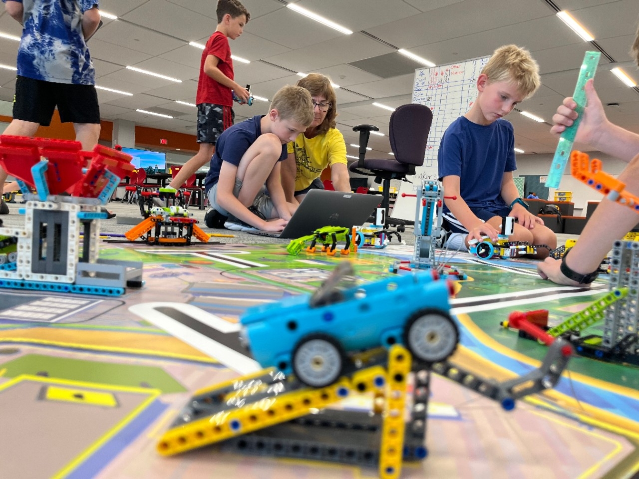 Elementary school-aged children program and test LEGO robots at a CINSAM Summer Camp.