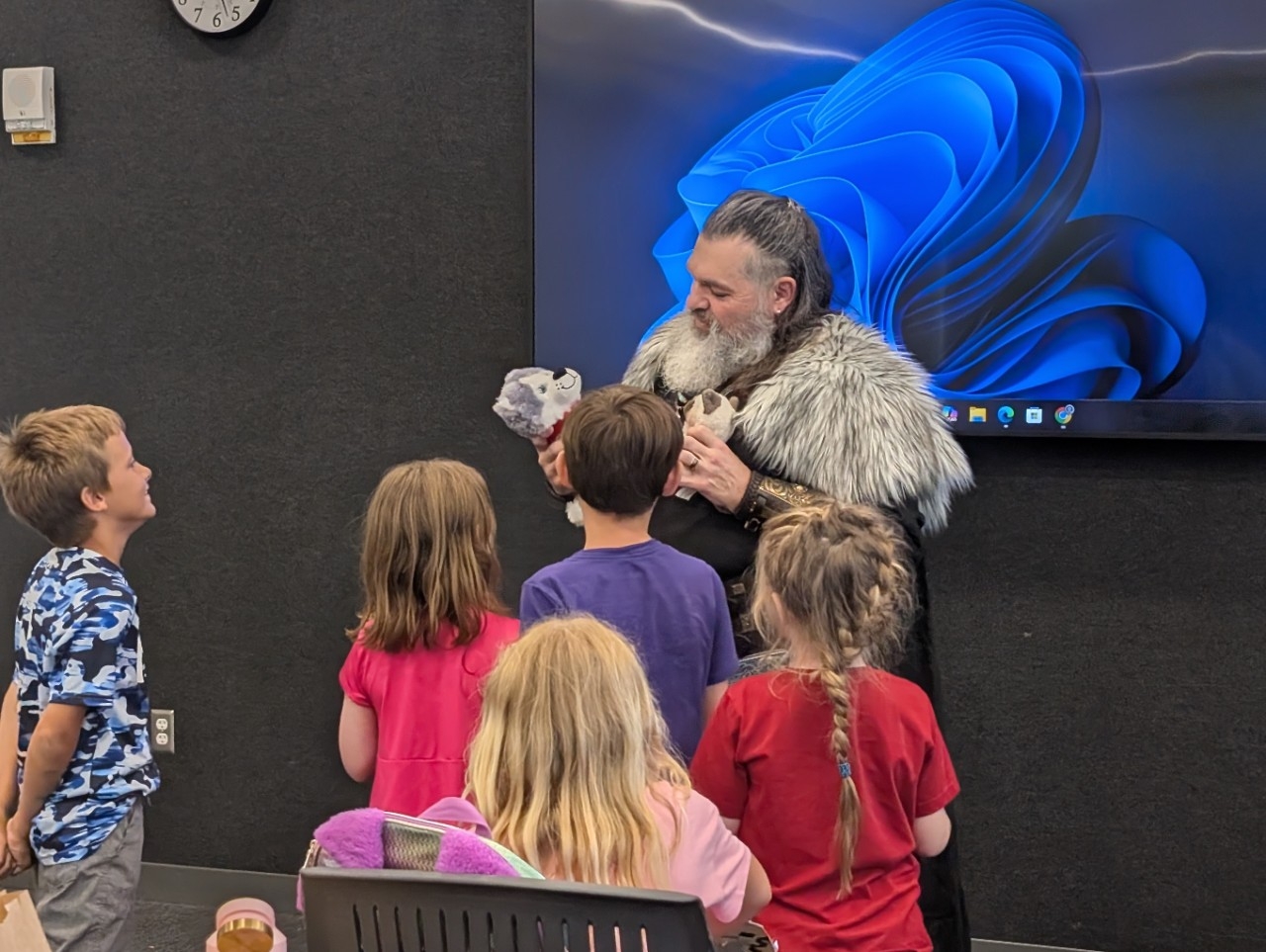 Man dressed up in viking clothing interacting with children at a presentation
