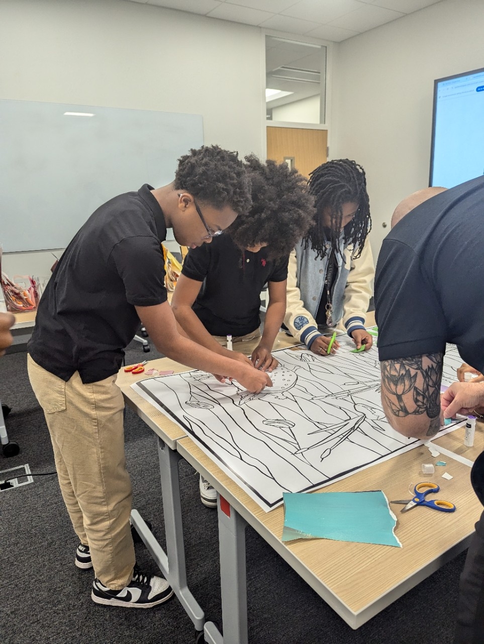 Middle school students gathered around an art project