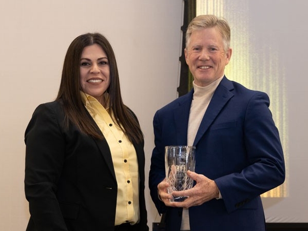 Mark Fischer holding award with Christina Roybal
