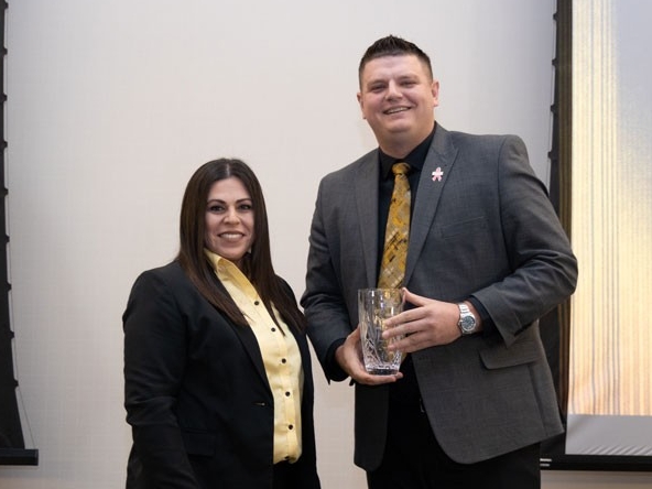 Drew McDonald holding award with Christina Roybal